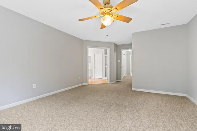 an empty room with a fan and a fan