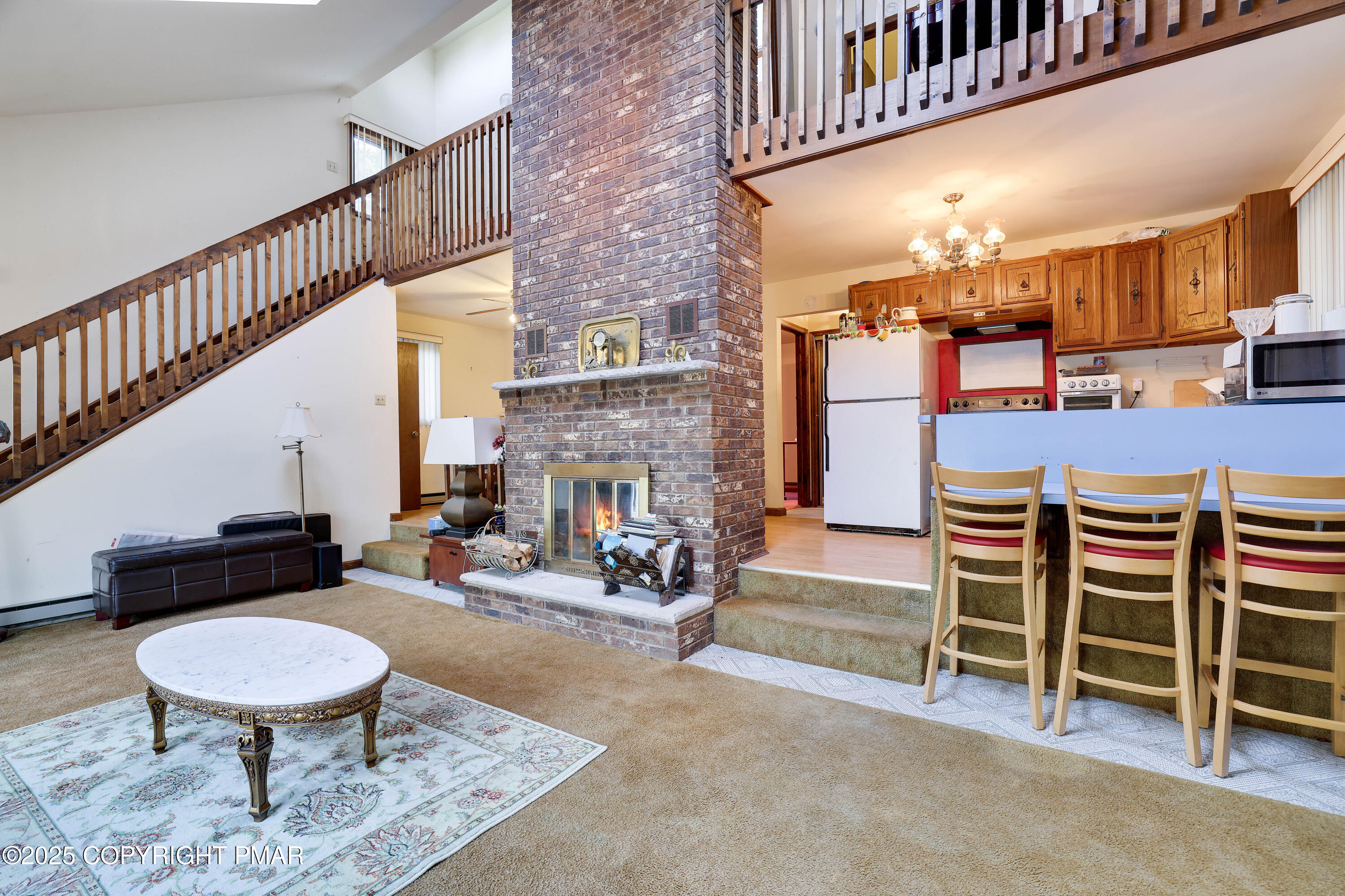 385 Saunders Drive Bushkill, PA 18324 - Photo 20 of 42 a living room with furniture a fireplace and a large window