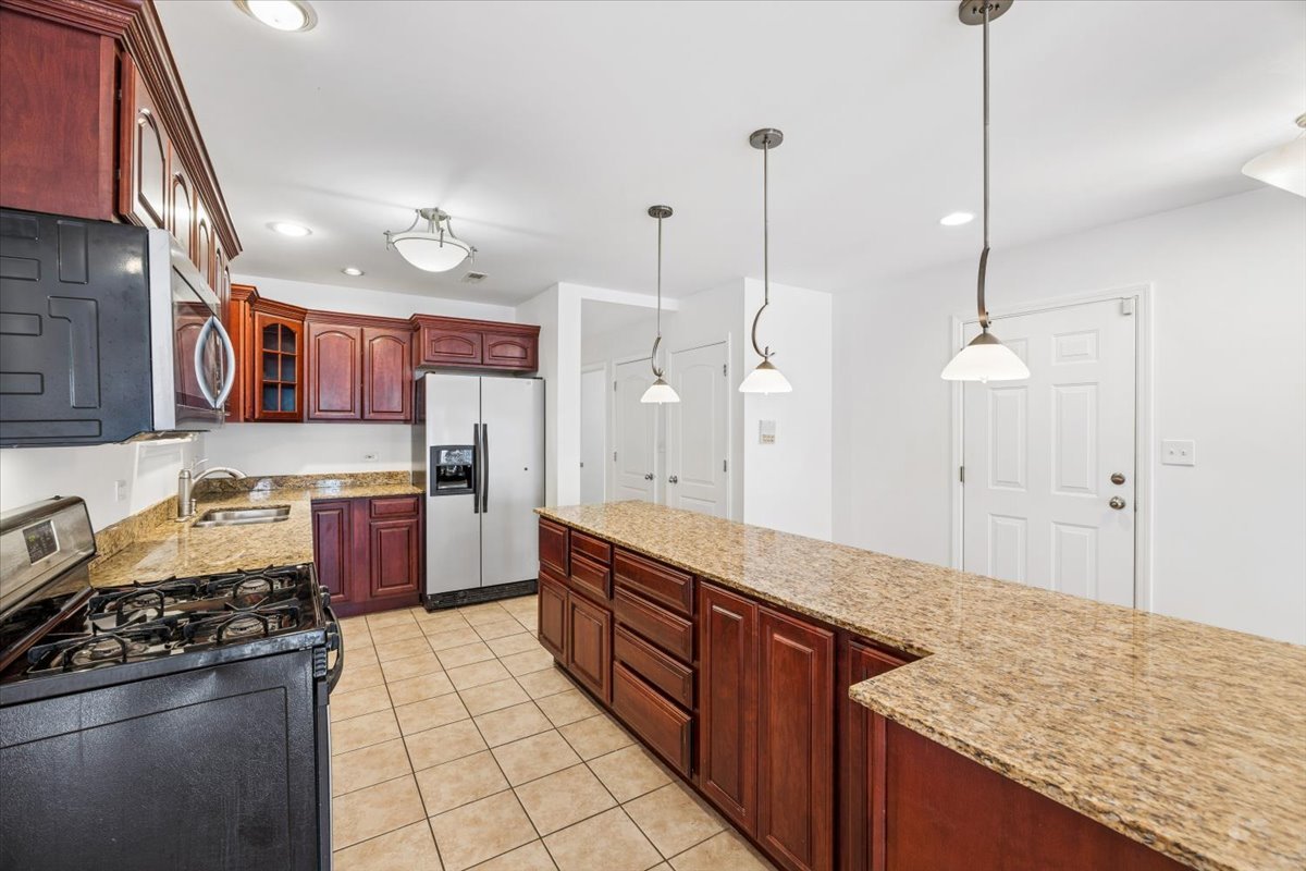 2363 East 70th Street, Unit 1 Chicago, IL 60649 - Photo 15 of 26 a kitchen with stainless steel appliances granite countertop a stove a sink and a refrigerator