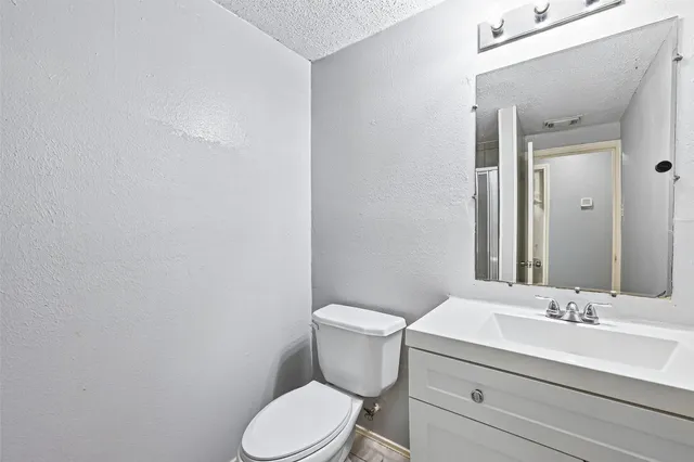 a bathroom with a toilet a sink and mirror