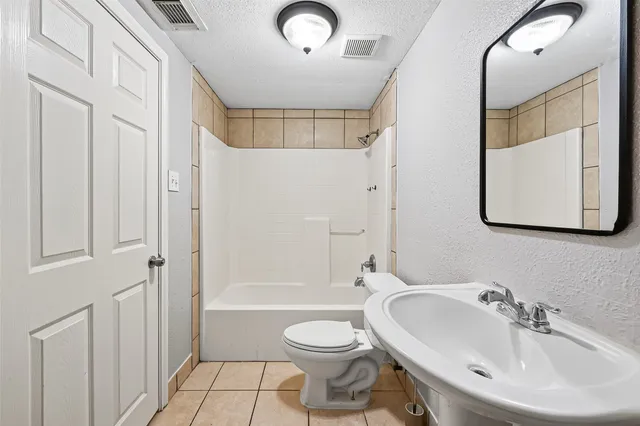 a bathroom with a toilet sink vanity tub and shower