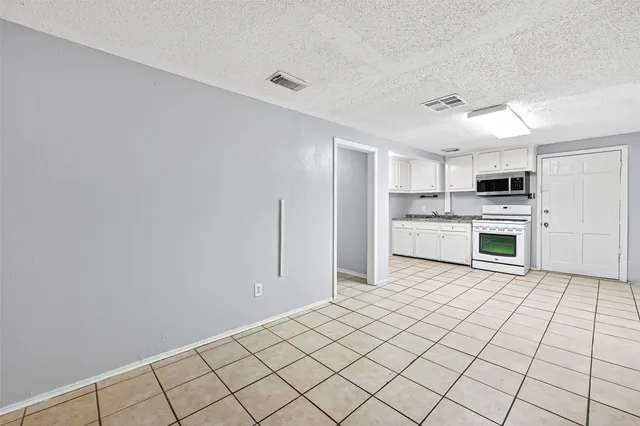 a view of a kitchen with white cabinets and white appliances