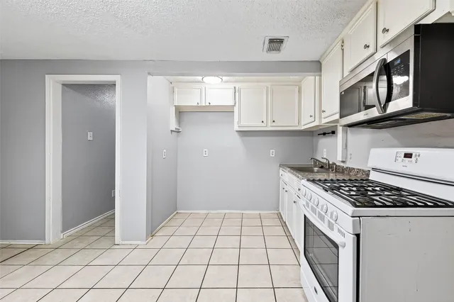 a kitchen with stainless steel appliances granite countertop a stove and a refrigerator