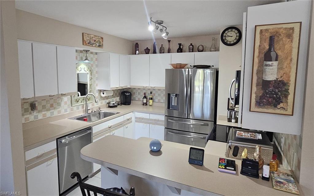 925 Southwest 47th Terrace, Unit 101 Cape Coral, FL 33914 - Photo 22 of 48 a kitchen with stainless steel appliances a refrigerator a sink a stove and white cabinets