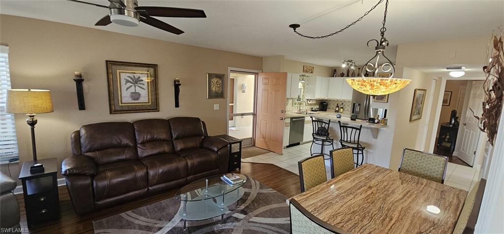 925 Southwest 47th Terrace, Unit 101 Cape Coral, FL 33914 - Photo 29 of 48 a living room with furniture a chandelier and a fireplace
