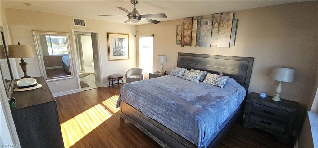 925 Southwest 47th Terrace, Unit 101 Cape Coral, FL 33914 - Photo 30 of 48 a bedroom with a bed and wooden floor