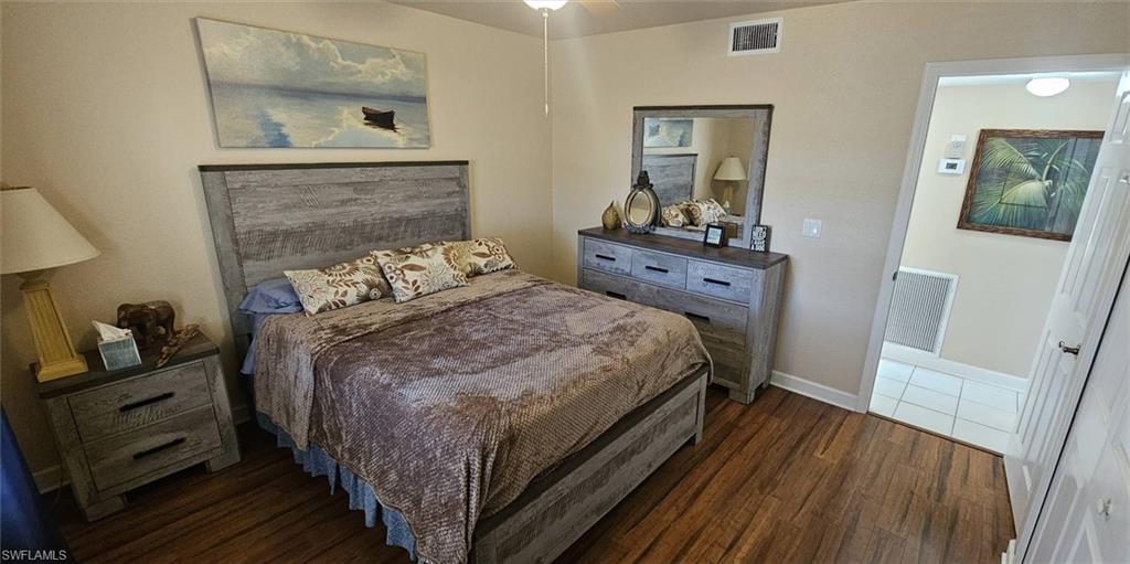 925 Southwest 47th Terrace, Unit 101 Cape Coral, FL 33914 - Photo 41 of 48 a bedroom with a bed and wooden floor