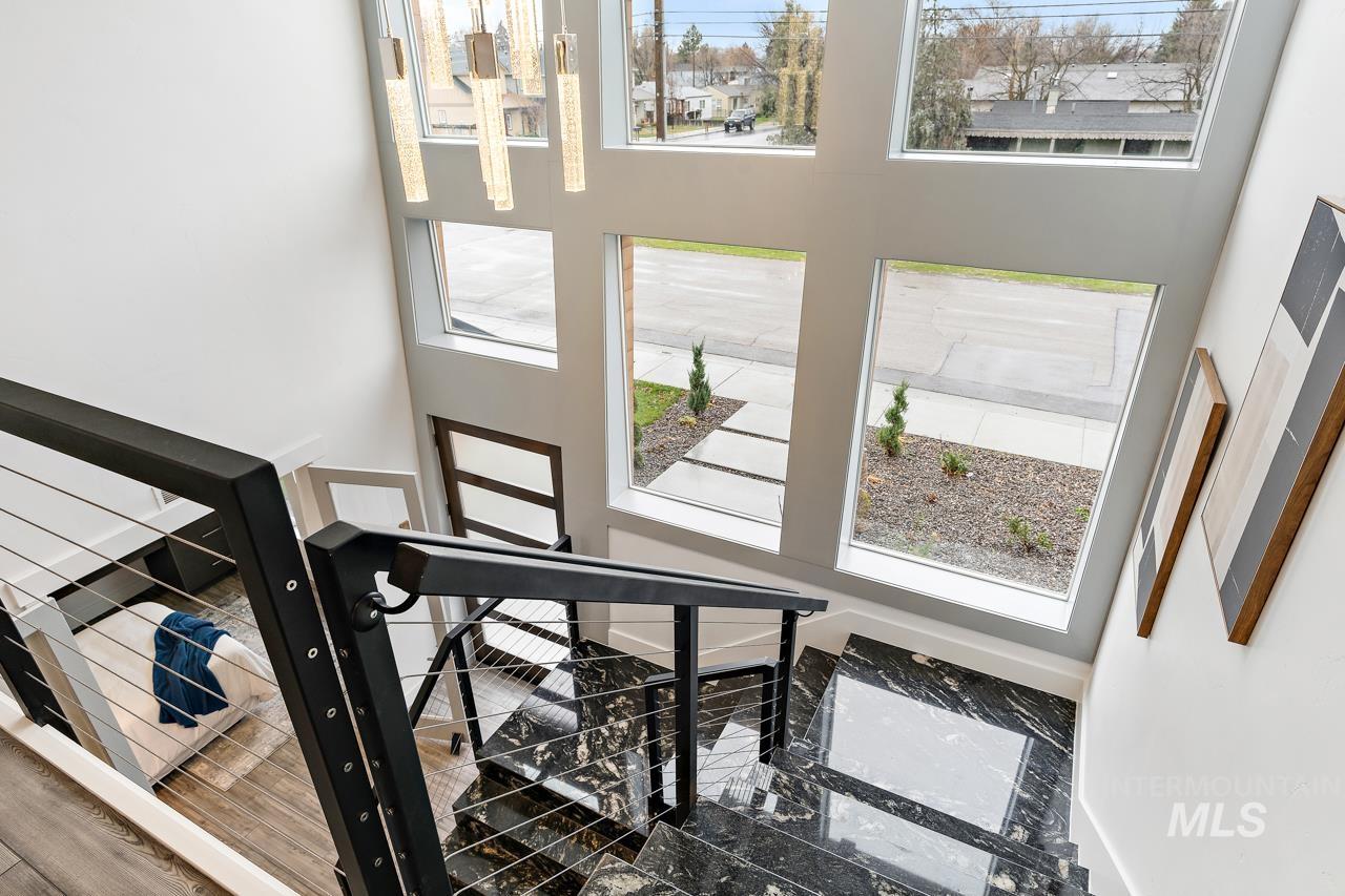 599 West Warren Street Boise, ID 83706 - Photo 33 of 41 Dramatic entryway featuring a contemporary chandelier, large picture windows, black metal and cable railing, and polished stone flooring