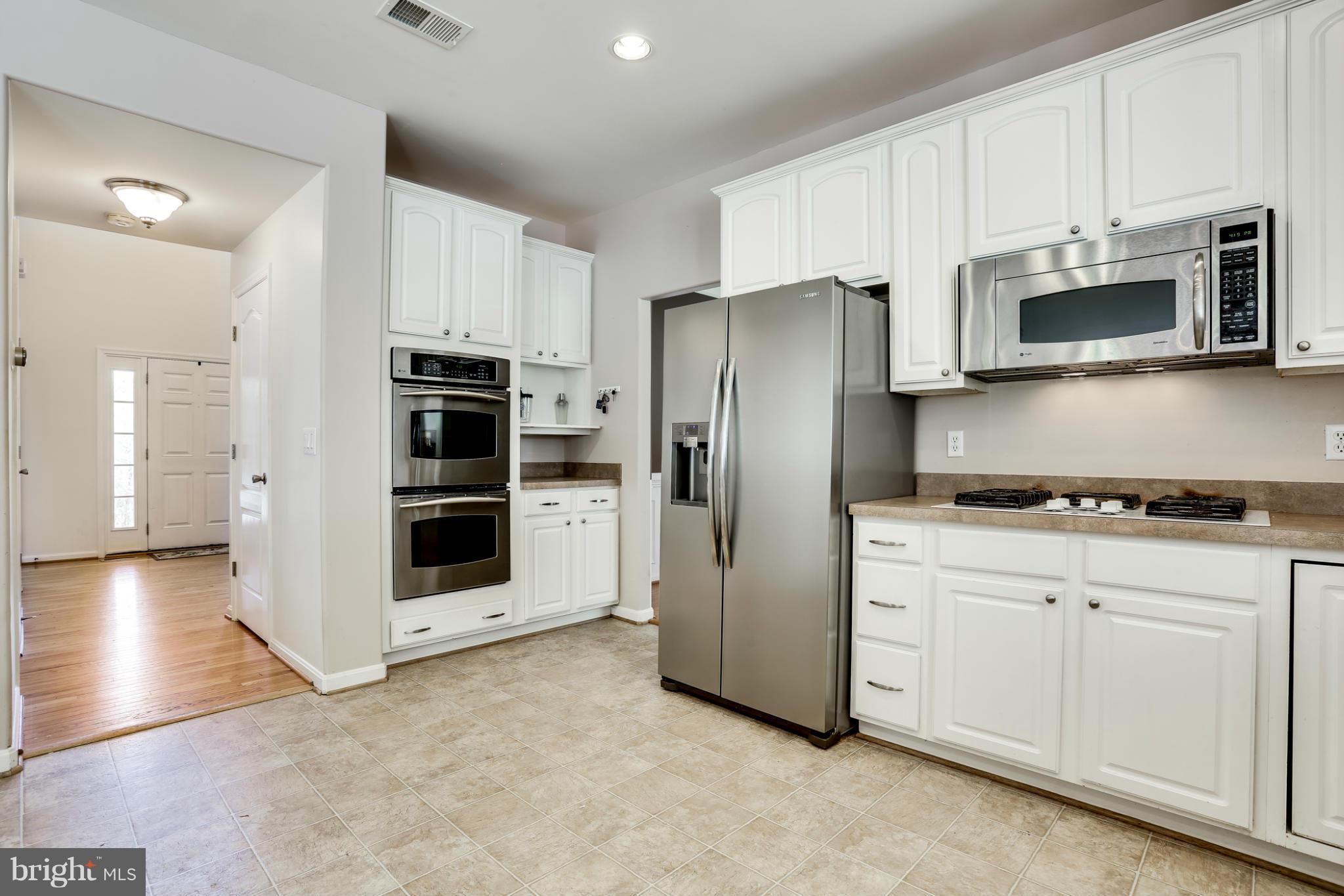6814 North Stuart Road King George, VA 22485 - Photo 11 of 30 a kitchen with stainless steel appliances a refrigerator stove and microwave
