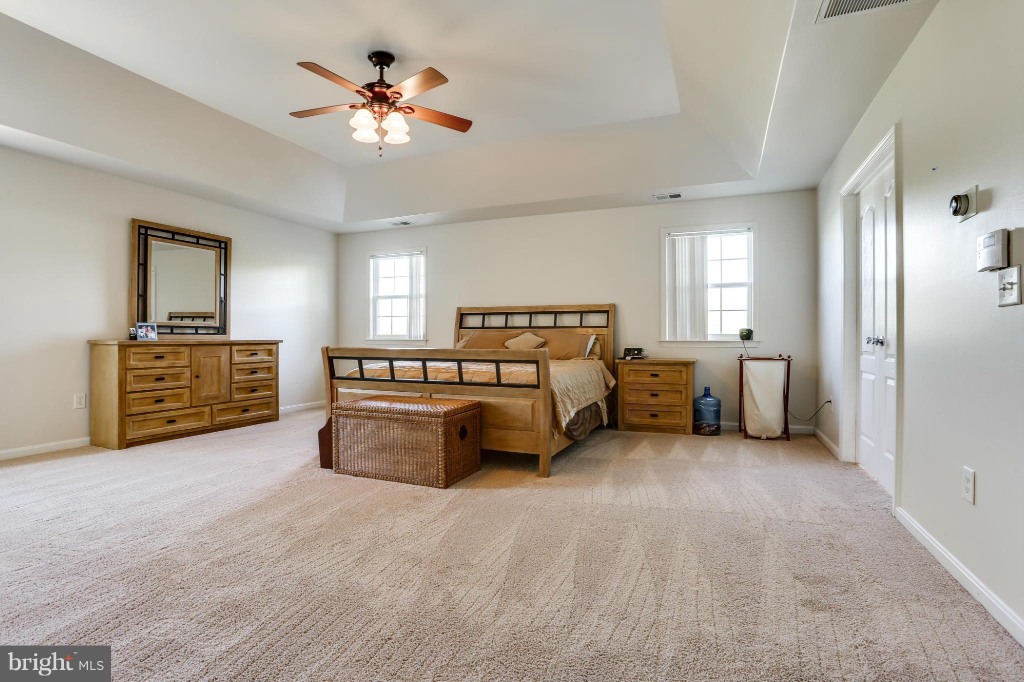 6814 North Stuart Road King George, VA 22485 - Photo 21 of 30 a spacious bedroom with a bed and a chandelier
