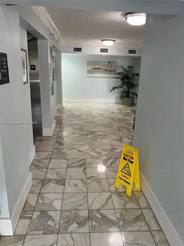 a view of kitchen and empty room with windows