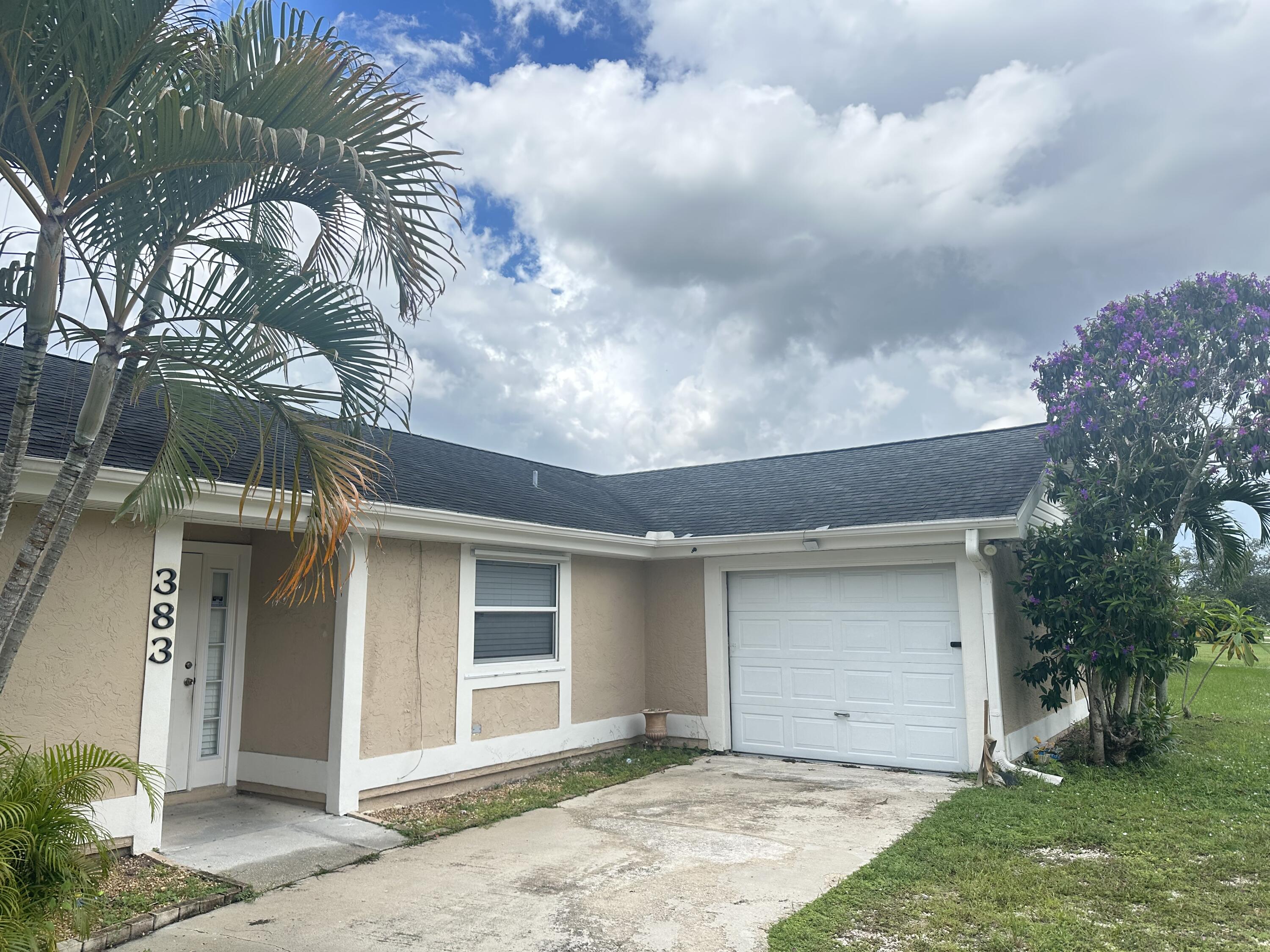 383 Southwest Tulip Boulevard Port St. Lucie, FL 34953 - Photo 2 of 26 a front view of a house with a yard