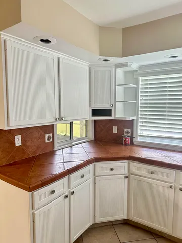 a kitchen with granite countertop a sink and white cabinets