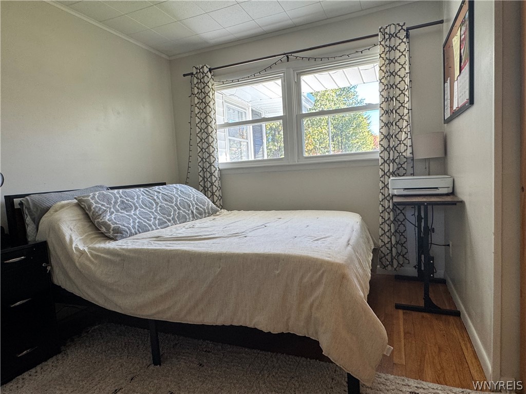 10180 Partridge Road Colden, NY 14080 - Photo 19 of 34 Natural light fills this cozy bedroom showcasing polished wood flooring and classic window casings.