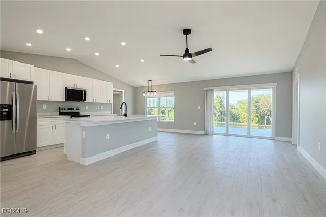 a view of kitchen with stainless steel appliances kitchen island wooden floor and window