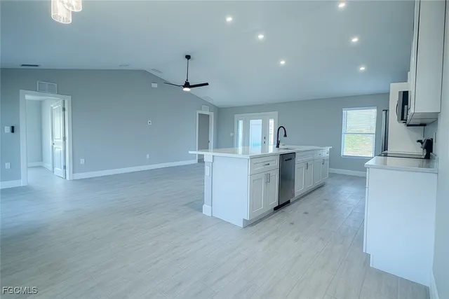 a large kitchen with stainless steel appliances a large counter top and a wooden floors