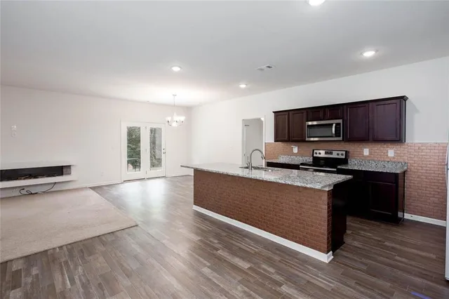 a large kitchen with a large window and stainless steel appliances