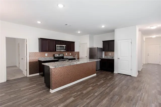 a large kitchen with a center island and stainless steel appliances