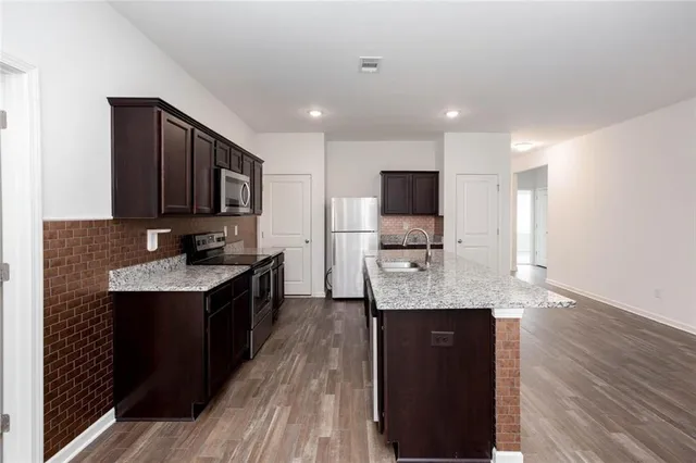 a kitchen with a sink a counter space and wooden floor