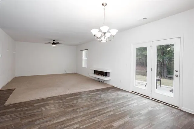 an empty room with windows and ceiling fan
