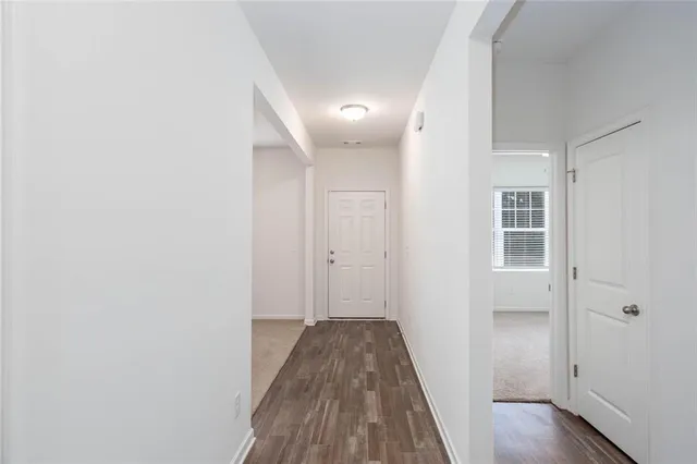 a view of a hallway with wooden floor and closet