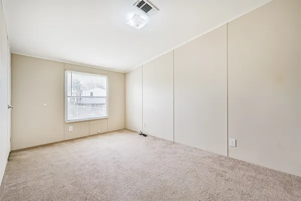 an empty room with windows and ceiling fan