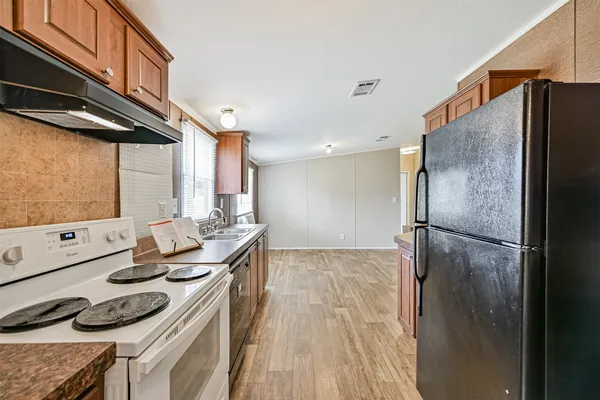 a kitchen with stainless steel appliances a refrigerator and a stove top oven