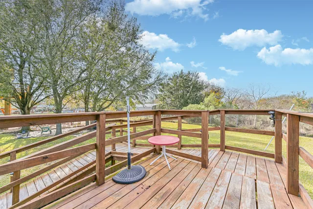 a view of a balcony with wooden floor and fence