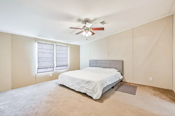 a spacious bedroom with a bed and a chandelier