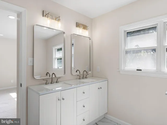 a bathroom with a double vanity sink and a mirror