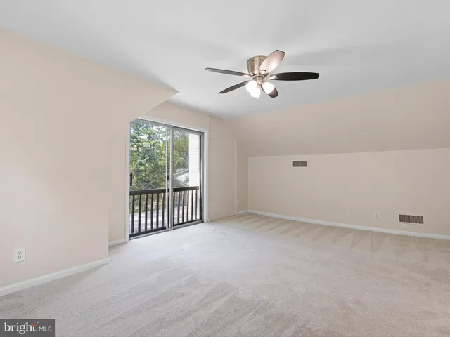 a view of a livingroom with a ceiling fan and window