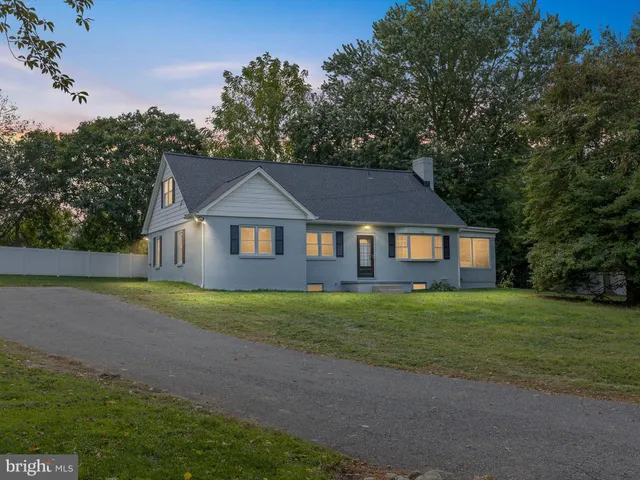 a front view of a house with yard and green space