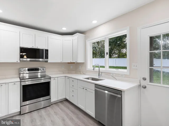 a kitchen with a sink stove top oven and cabinets