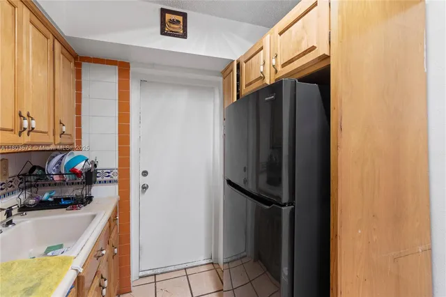 a kitchen with a refrigerator and a sink