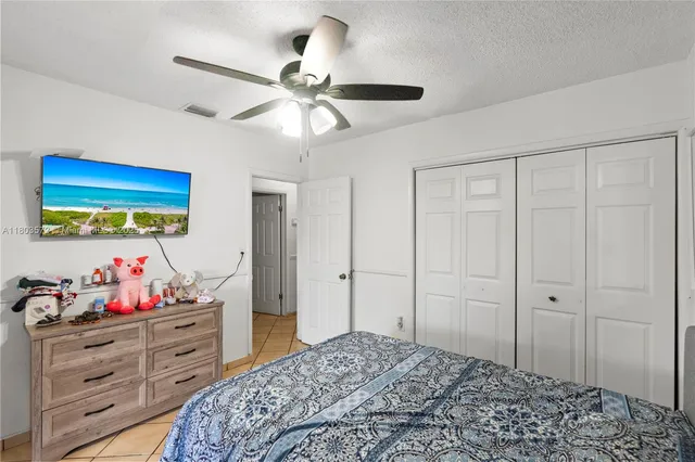 a bedroom with a bed and a chandelier fan