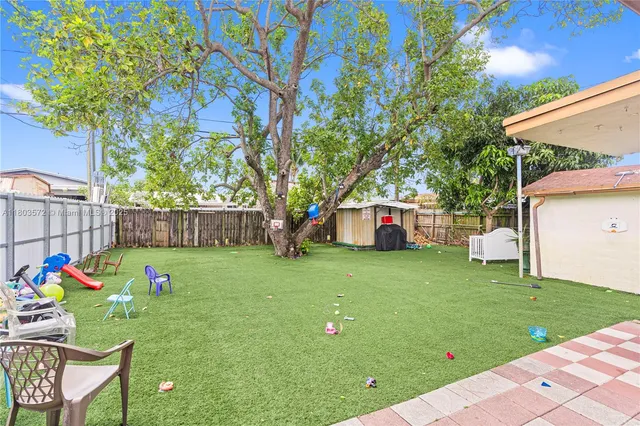 a backyard of a house with table and chairs
