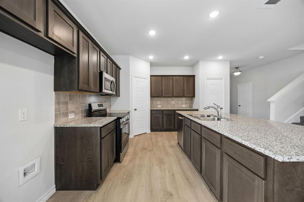 504-506 Mockingbird Lane Denton, TX 76209 - Photo 10 of 30 a kitchen with stainless steel appliances granite countertop a sink stove and cabinets