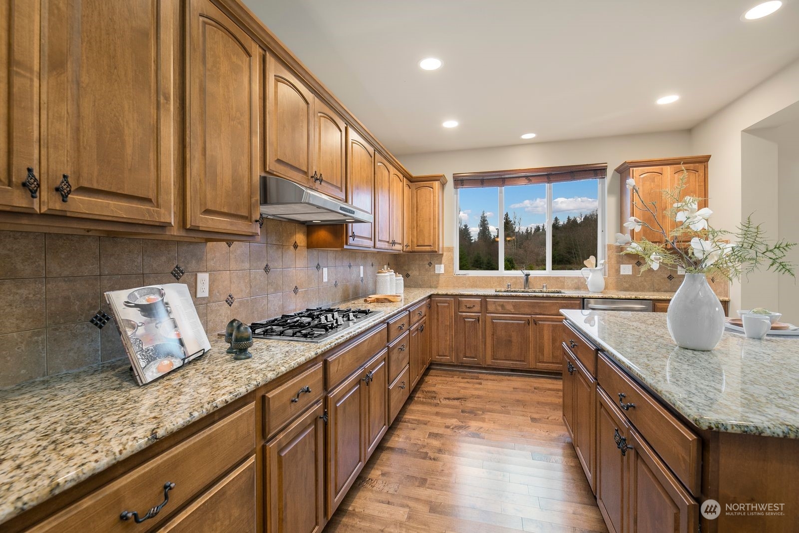9912 Northeast 151st Street Bothell, WA 98011 - Photo 6 of 33 a kitchen with stainless steel appliances granite countertop a stove a sink and a wooden cabinets