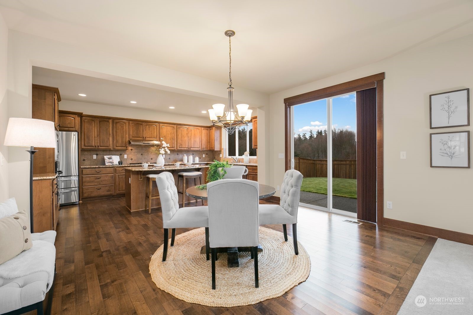 9912 Northeast 151st Street Bothell, WA 98011 - Photo 7 of 33 a dining room with furniture a chandelier and wooden floor