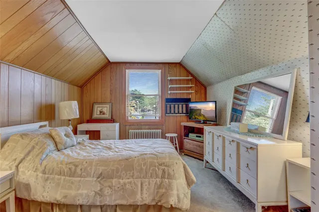 a bed room with a bed and a flat tv screen on dresser