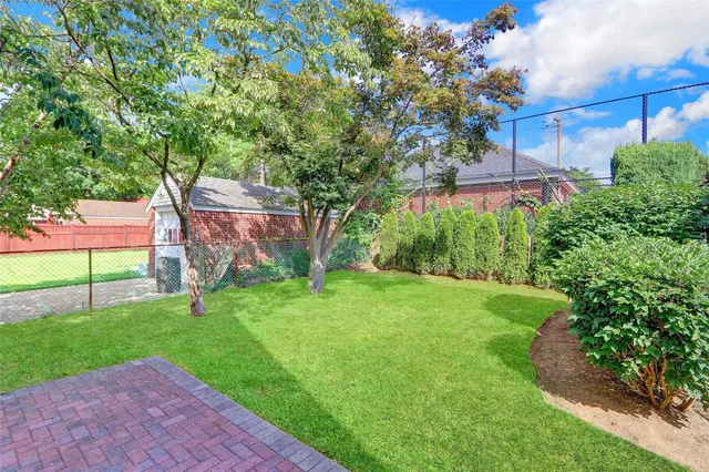 a backyard of a house with plants and large trees