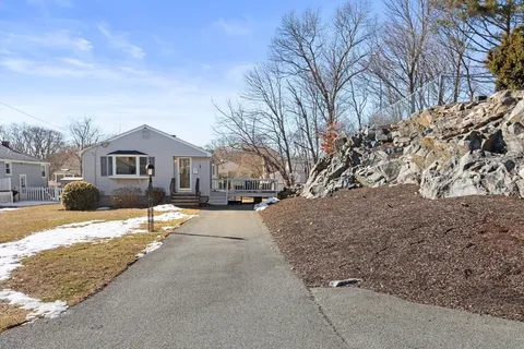 a front view of a house with a yard covered in snow