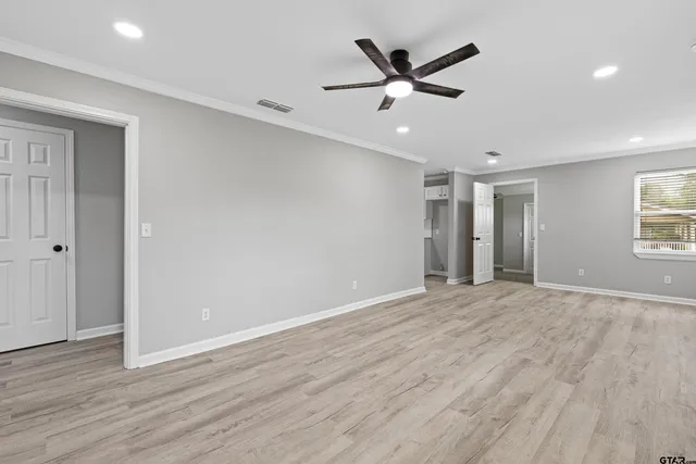 an empty room with wooden floor and windows