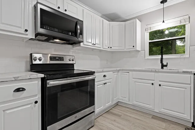a kitchen with cabinets stainless steel appliances a sink and a stove