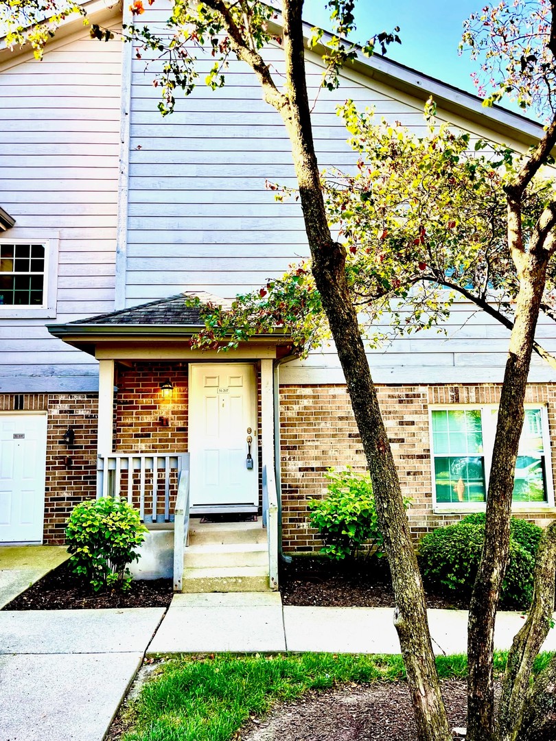 31 Foxcroft Road, Unit 207 Naperville, IL 60565 - Photo 3 of 6 a front view of a house with garden