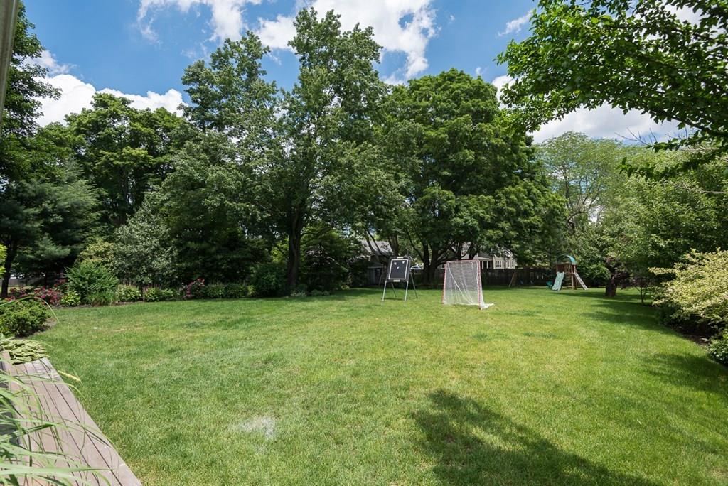44 Middle Street Hingham, MA 02043 - Photo 21 of 23 a backyard of a house with plants and large trees