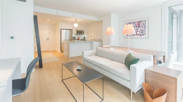 a living room with furniture and kitchen view