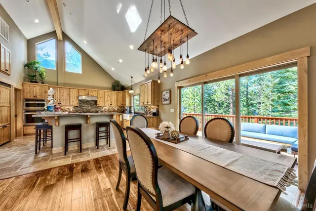 a dining room with furniture a chandelier and wooden floor