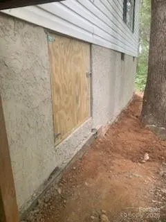 a view of a wooden house with a yard and large tree