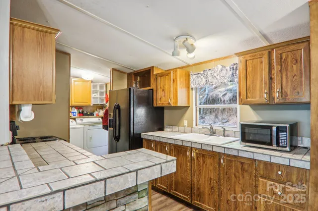 a kitchen with stainless steel appliances kitchen island granite countertop a refrigerator a stove a sink dishwasher with a dining table and chairs